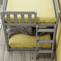 Top-down view of white bunk bed frame and ladder with yellow bedding, gray blanket and light wood plank flooring