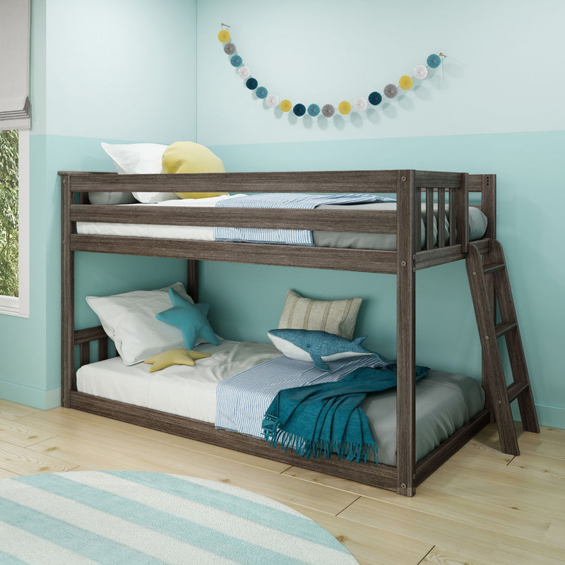 Dark wood twin-over-full bunk bed in a coastal kids' bedroom with aqua walls, striped rug, decorative garland, shark plush and star pillows