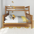 Modern wooden twin-over-full bunk bed with ladder, gray knit bedding and yellow accent pillows, brass wall sconces and neutral curtains in a bright kids' bedroom