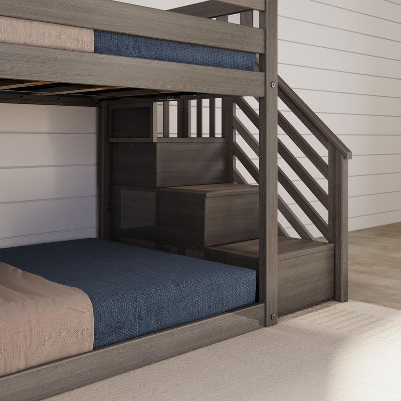 Grey wooden twin-over-twin bunk bed with stairs and built-in storage drawers, navy blue mattresses, space-saving modern farmhouse kids' bedroom
