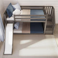 Gray wooden kids bunk bed with slide, built-in stairs, blue and beige bedding and cloud pillow in modern children's bedroom
