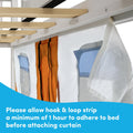 Close-up of a bed privacy curtain attached with hook-and-loop (Velcro) strip to a bed frame, showing fabric pockets and wooden slats, note to allow 1 hour for adhesive to adhere