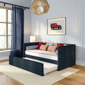 Modern nautical children's bedroom with navy daybed and pull-out trundle, blue-striped wallpaper, navy sheer curtains, red accent pillows and framed red jeep art