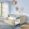 Beige upholstered trundle daybed in modern blue bedroom with sheer curtains, woven wall decor and rattan pendant.