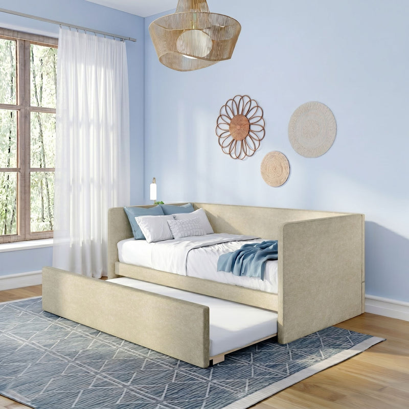 Beige upholstered trundle daybed in modern blue bedroom with sheer curtains, woven wall decor and rattan pendant.