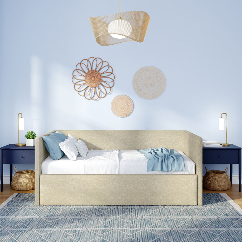 Beige upholstered daybed in boho coastal bedroom with blue pillows, woven rattan wall decor, rattan pendant light and navy bedside tables