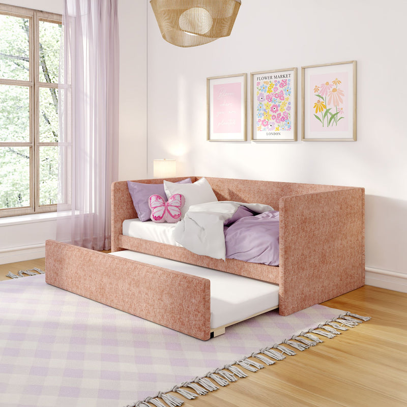 Cozy pink girl's bedroom with blush pull-out daybed, lavender bedding, butterfly cushion, floral framed prints, sheer pink curtains and rattan pendant lamp by a sunny window