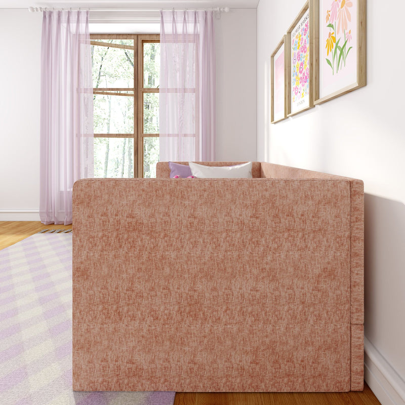 Cozy modern living room interior with blush pink sofa, sheer pink curtains, wooden window frame, pastel floral wall art and light checkered rug