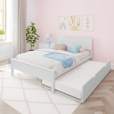 Kids' pastel bedroom with white trundle bed, pink scalloped wallpaper, rainbow and sun wall art, blue bedside lamp, pastel pillows and potted plant
