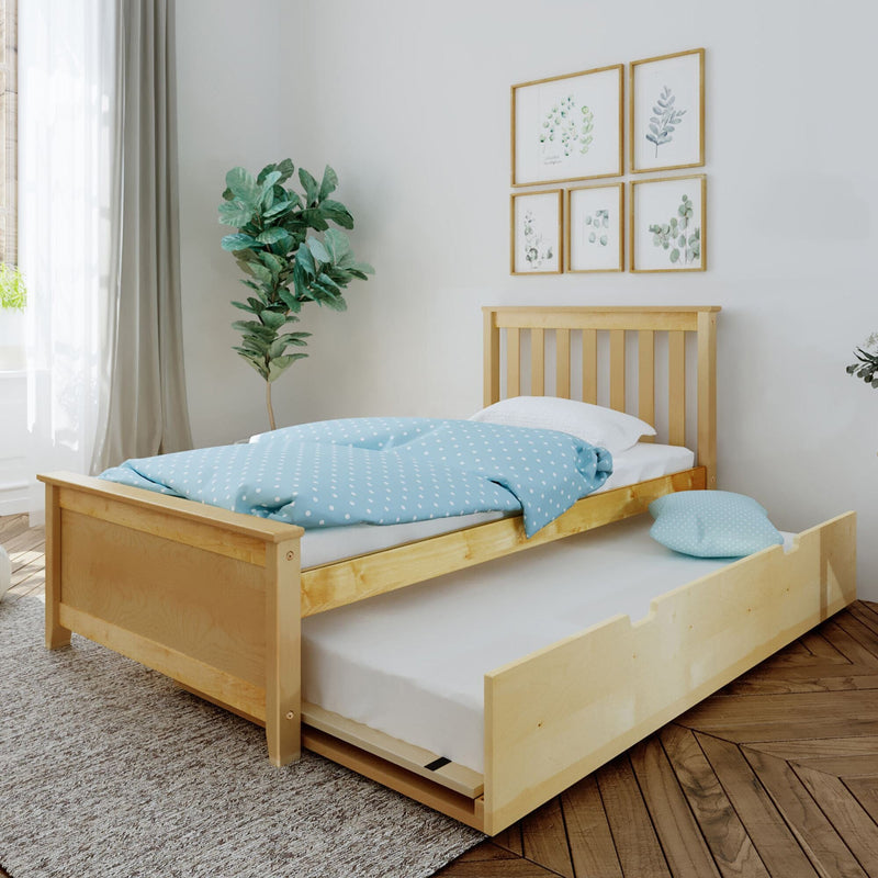 Kids wooden twin bed with trundle and blue polka-dot bedding in bright bedroom with potted plant and botanical wall art