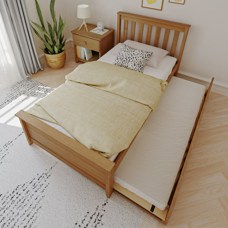 Wooden trundle bed with yellow duvet in a Scandinavian-style bedroom, slatted headboard, pull-out mattress, wooden nightstand, potted snake plant and speckled throw pillow