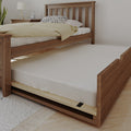Solid wood twin trundle bed with pull-out mattress, beige duvet and spotted pillow in modern farmhouse bedroom