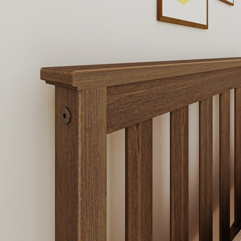Close-up of walnut wooden slat headboard against a white bedroom wall, rustic modern bed frame with visible wood grain texture