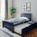 Navy blue twin bed with pull-out trundle, blue striped bedding, sports-themed framed wall art and fiddle leaf fig plant in modern kids' bedroom decor