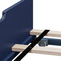 Close-up of blue metal dolly frame with wooden slats, black securing strap and swivel caster wheel for heavy-duty furniture moving