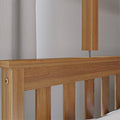 Modern oak slatted bed headboard with wooden bedside lamp and neutral linen curtain in minimalist bedroom