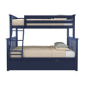 Navy blue wooden bunk bed with ladder, beige quilted bedding and pillows, and pull-out under-bed storage trundle on white background