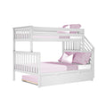 White wooden twin-over-full bunk bed with stairs, pull-out trundle drawer and pink bedding and pillows for kids' bedroom