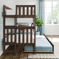 Dark wood bunk bed with pull-out trundle mattress in bright kids' bedroom with blue curtains, patterned wallpaper, throw pillows and potted plant