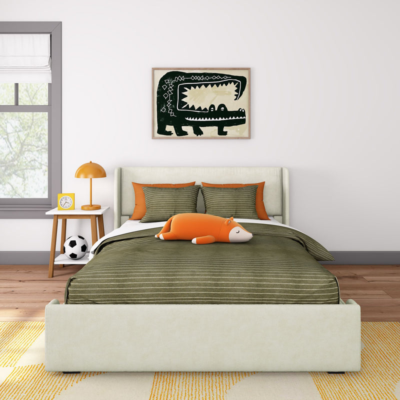 Modern kids bedroom with green striped bedding, orange accent pillows, fox plush toy, crocodile wall art and bedside lamp.