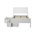 White wooden platform bed frame with headboard and slatted mattress support and built-in under-bed storage drawers on casters, front view