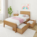 Modern minimalist bedroom with wooden platform bed and under-bed trundle storage drawers, white quilted bedding, pink throw and pastel pillows, wooden nightstand with lamp, potted plant and rainbow wall art