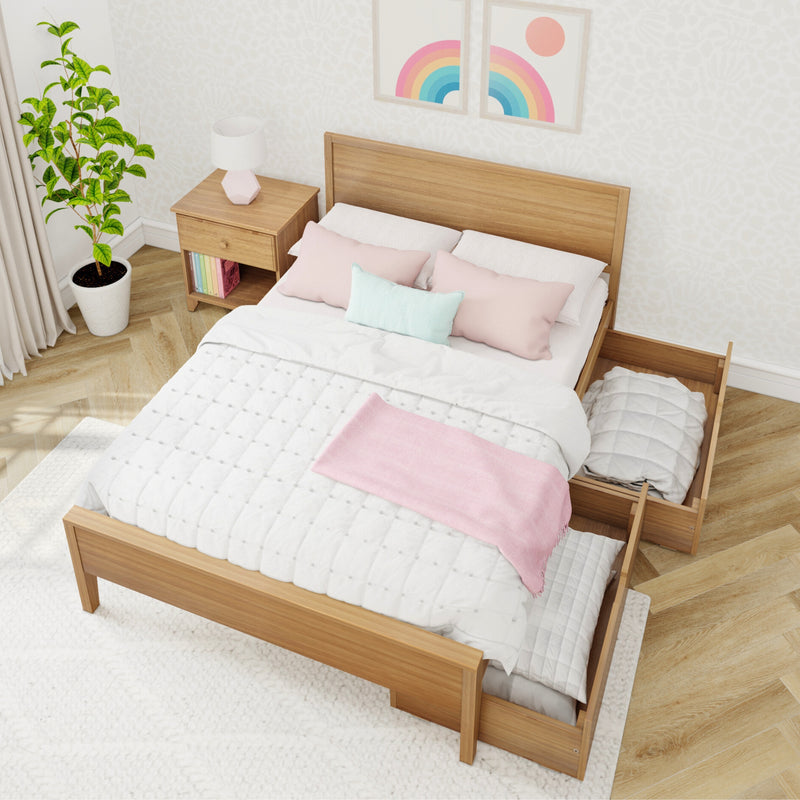 Minimalist Scandinavian bedroom with wooden storage bed, white quilted bedding, pastel pink throw and pillows, nightstand lamp, potted plant and rainbow wall art
