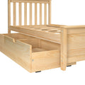Solid pine platform bed frame with vertical slatted headboard and built-in under-bed storage drawers in natural wood finish