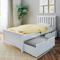 White wooden children's bed with pull-out storage drawers and yellow polka-dot duvet in modern nursery with fiddle-leaf plant and framed botanical art