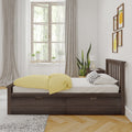 Scandinavian minimalist bedroom with dark wooden platform bed, yellow duvet, polka-dot pillow, large window with sheer curtains, indoor plants and framed fruit art