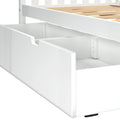 Pull-out white wooden under-bed storage drawer with divided compartments integrated into a slatted bed frame, modern bedroom storage solution