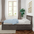 Modern cozy bedroom with dark wood platform bed and under-bed storage, blue polka-dot duvet, large window with potted plants, sheer curtains and gallery animal prints