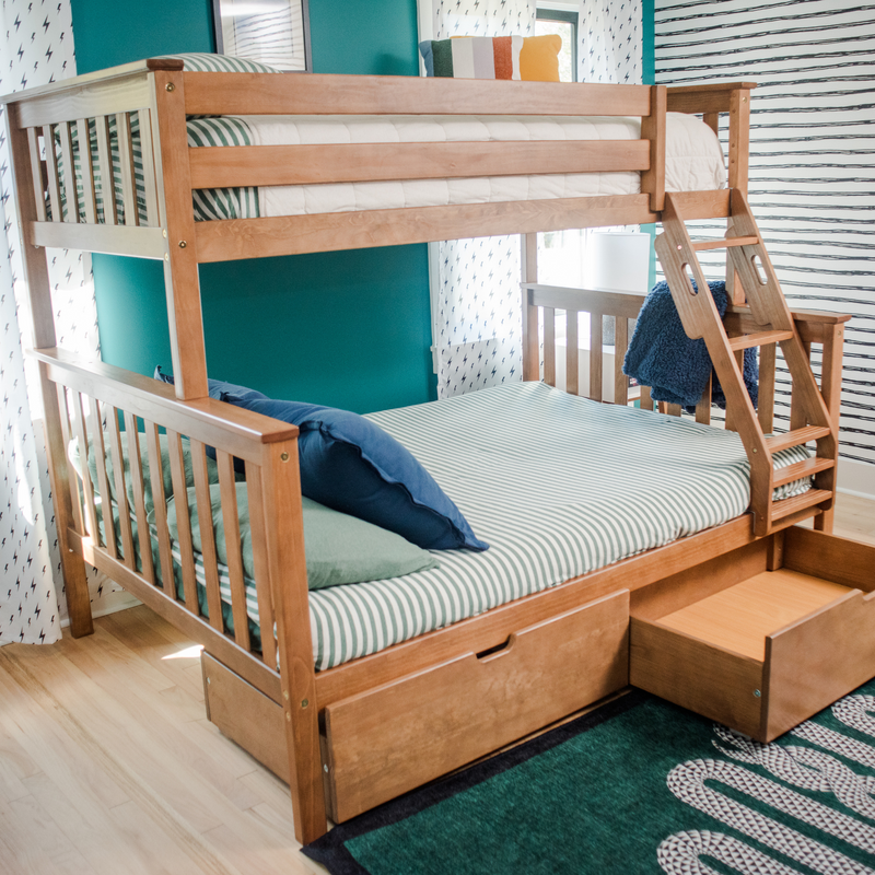 Solid wood twin-over-twin bunk bed with ladder and under-bed storage in modern kids' bedroom with teal accent wall and striped bedding