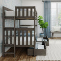 Gray wooden bunk bed with built-in storage drawers, ladder and white striped bedding in coastal kids bedroom with blue curtains and potted fiddle-leaf fig