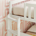 White wooden bunk bed with safety rail, blush pink bedding and retro abstract pink wallpaper in children's bedroom