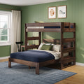 Dark wood bunk bed with built-in desk in a kids' bedroom with green paneled walls, navy bedding and framed sports prints