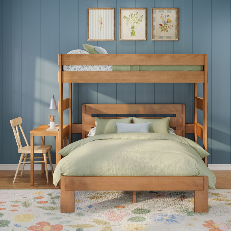 Wooden bunk bed with sage green bedding against a blue paneled wall, floral framed prints above, wooden desk and chair and a floral area rug in a cozy kids' bedroom