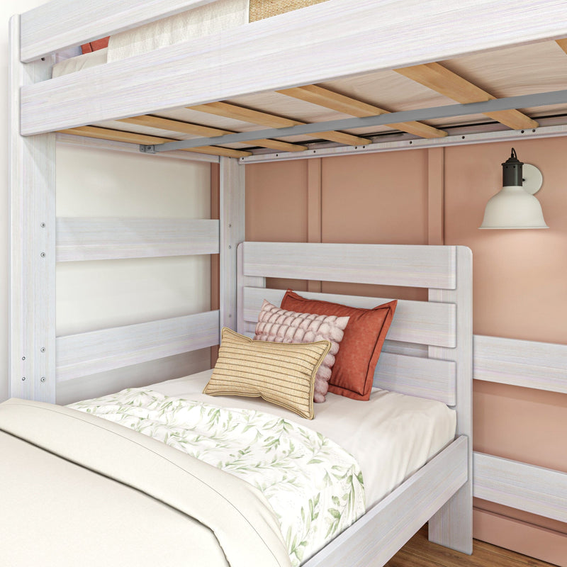 Whitewashed wooden twin bunk bed with exposed slats, floral bedding, textured pillows and wall sconce in cozy kids' bedroom