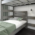 Grey wood loft bunk bed with slatted headboard, green bedding, patterned pillow and white wall sconce in modern kids' bedroom