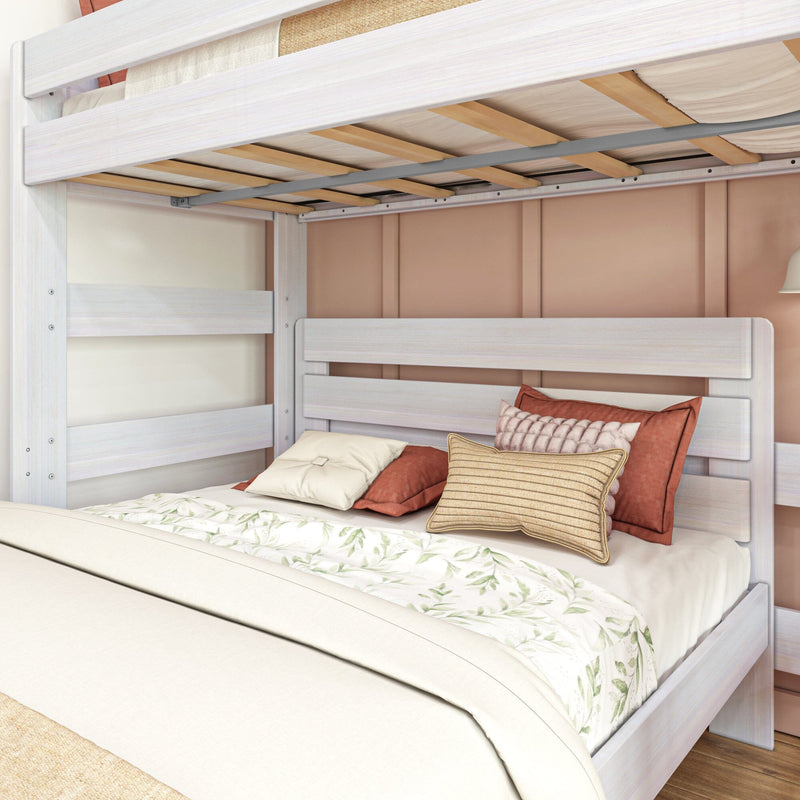 Whitewashed wooden bunk bed with exposed slatted mattress support and metal rail, floral duvet and rust-colored decorative pillows on lower bed in modern bedroom