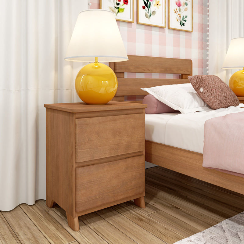 Wooden nightstand with yellow round bedside lamp beside a wooden bed with pink bedding, decorative pillows, floral wall art and hardwood floor in a modern pastel bedroom