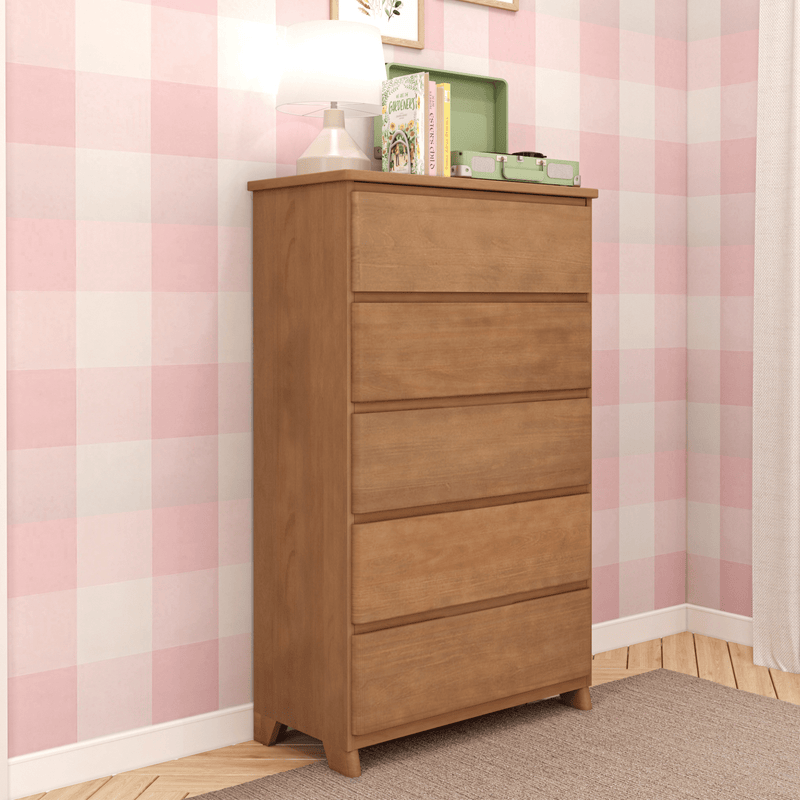 Natural wood five-drawer dresser in pink checkered nursery corner with lamp, children's books and green record player — bedroom storage