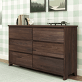 Mid-century modern dark walnut six-drawer wood dresser for bedroom storage, styled with books, a white alarm clock and a turntable against green plaid wallpaper