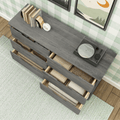 Top-down view of gray wooden dresser with open drawers of folded blankets and a record player on top against green plaid wallpaper