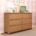 Six-drawer oak dresser in pink checkered nursery with lamp, children's books, floral wall art and green record player