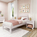 Pastel pink bedroom with white wooden bed, blush duvet and textured pillows, pom-pom white curtains, gold-framed floral gallery wall and bedside lamps