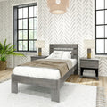 Modern farmhouse bedroom with gray wood bed, matching nightstands and lamps, herringbone wallpaper, black-framed windows, woven pendant light and potted fern