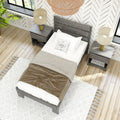 Top-down view of a modern farmhouse bedroom with a gray wooden bed and headboard, matching nightstands with beige table lamps, a wicker pendant light, herringbone patterned wallpaper, light hardwood floors and a white textured rug