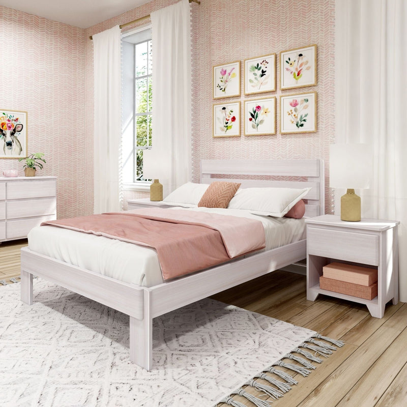 Blush pink bedroom with white wooden bed frame, soft pink bedding, floral gallery wall, white curtains, bedside lamps and textured rug