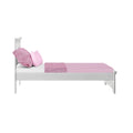 White wooden twin bed with pink fitted sheet, pink textured throw and matching pillows, isolated on white background